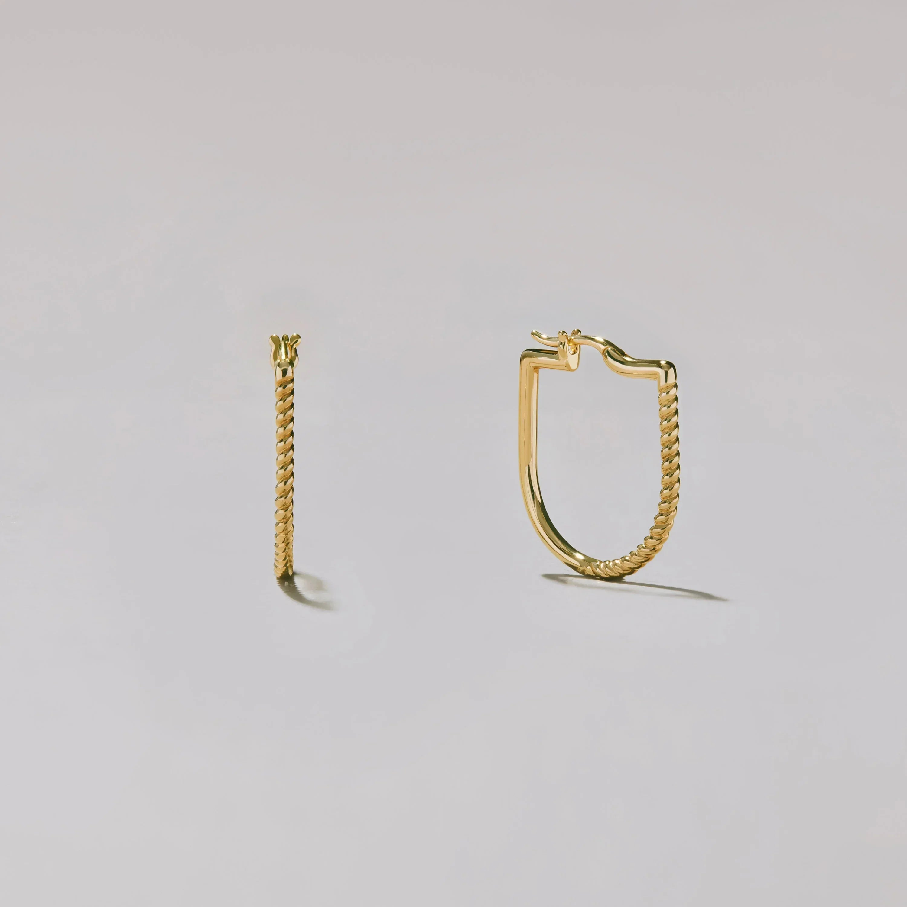 Gold hoop earrings on a light gray background