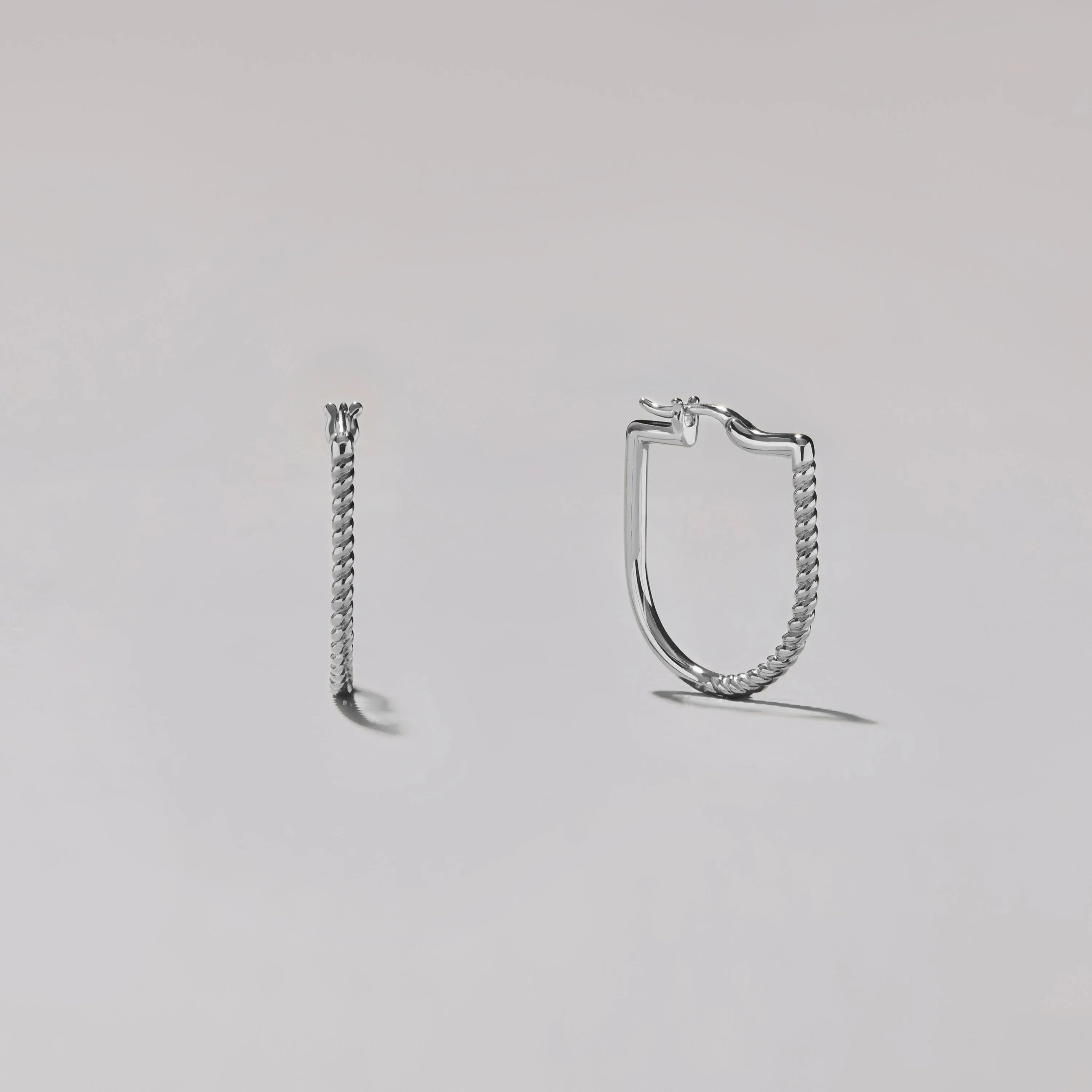Pair of silver hoop earrings on a light gray background