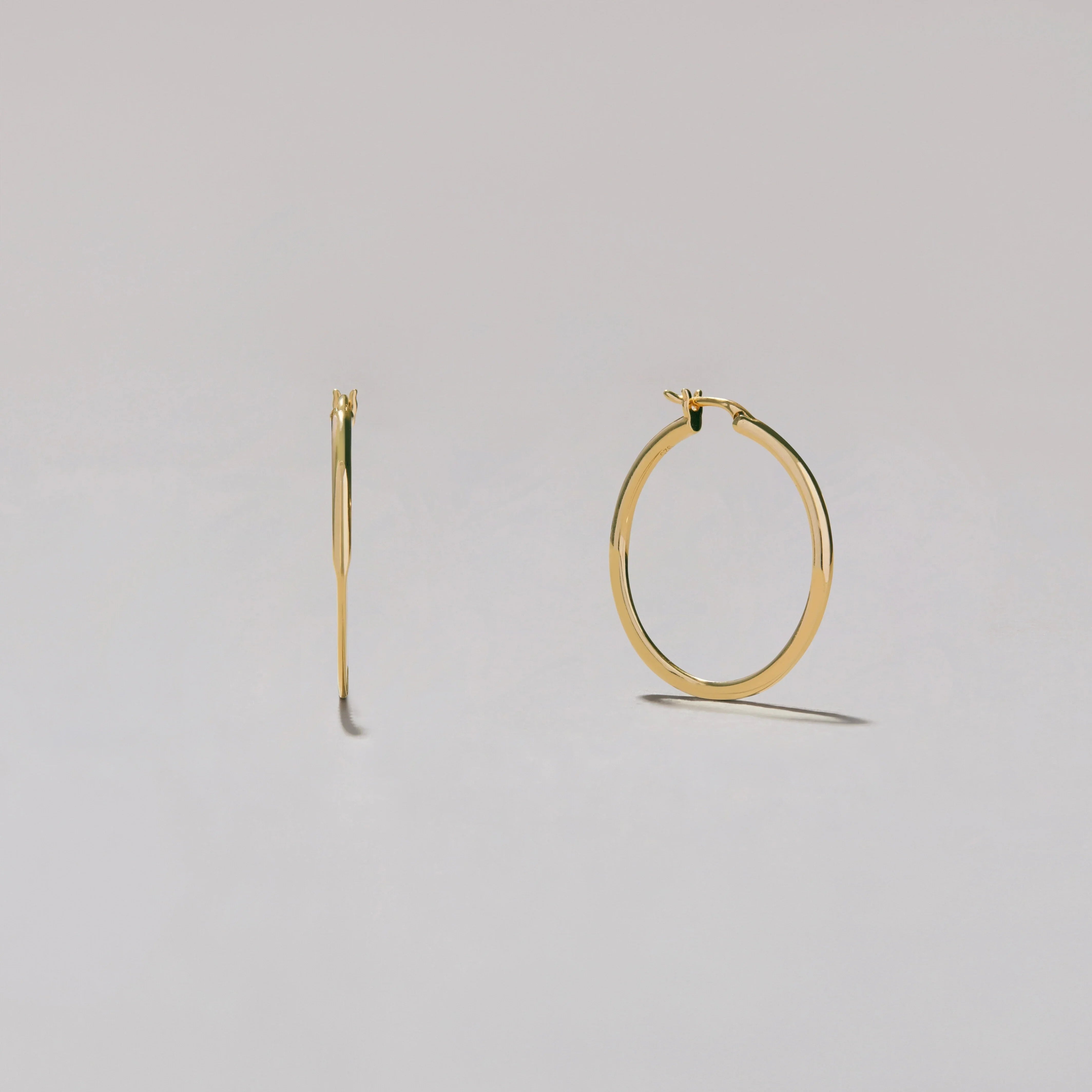 Gold hoop earrings on a light gray background