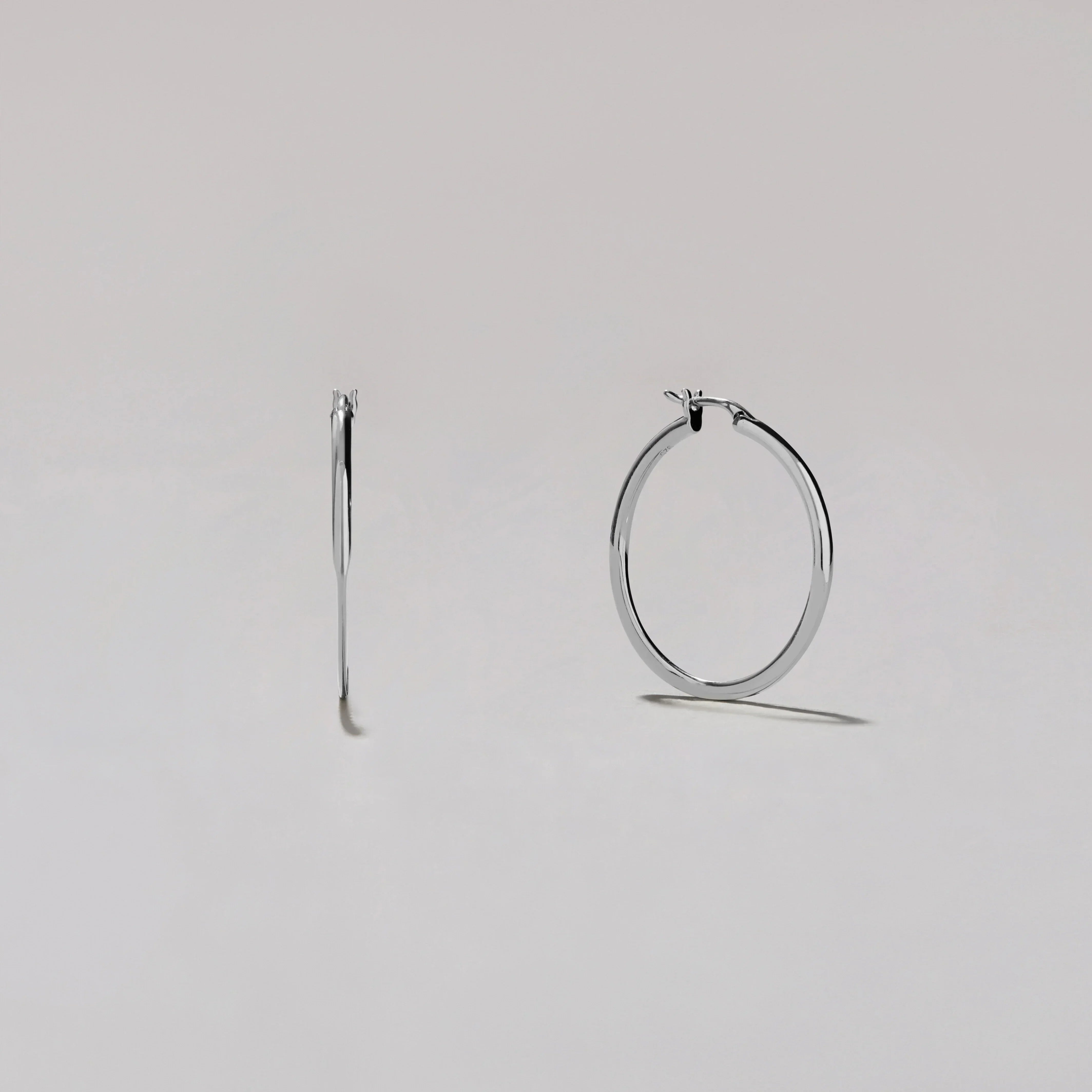 Silver hoop earrings on a light gray background
