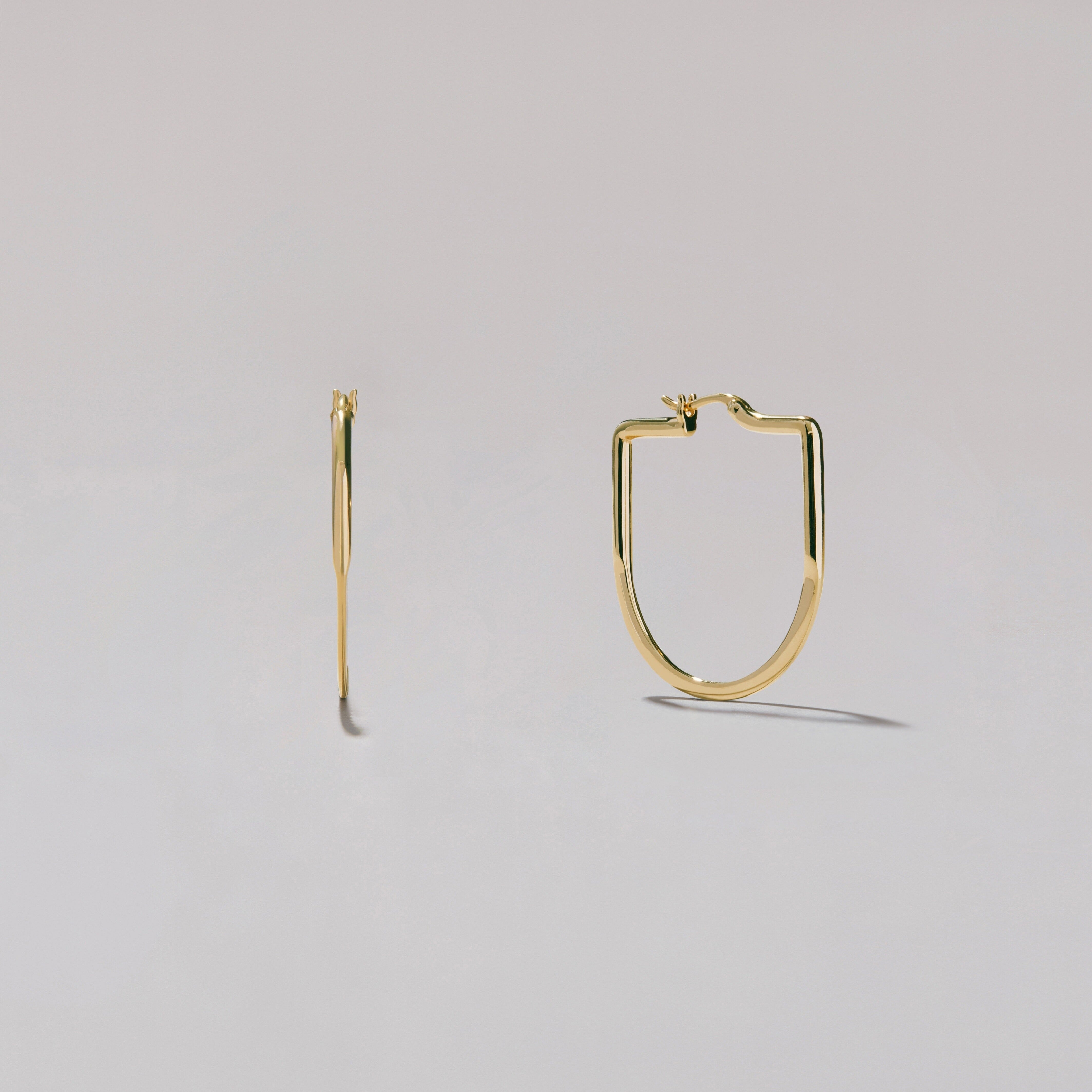 Gold hoop earrings on a light gray background