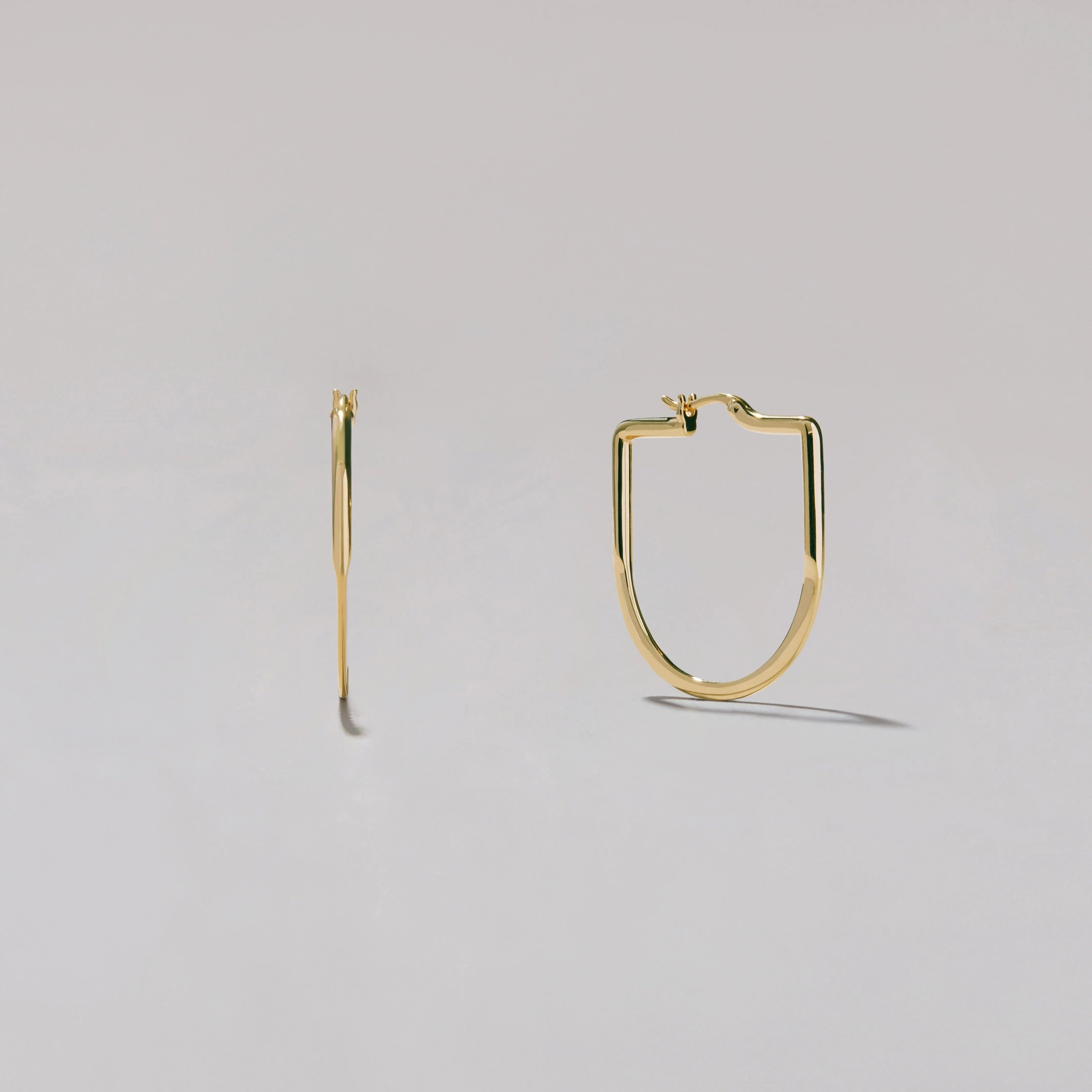 Gold hoop earrings on a light gray background
