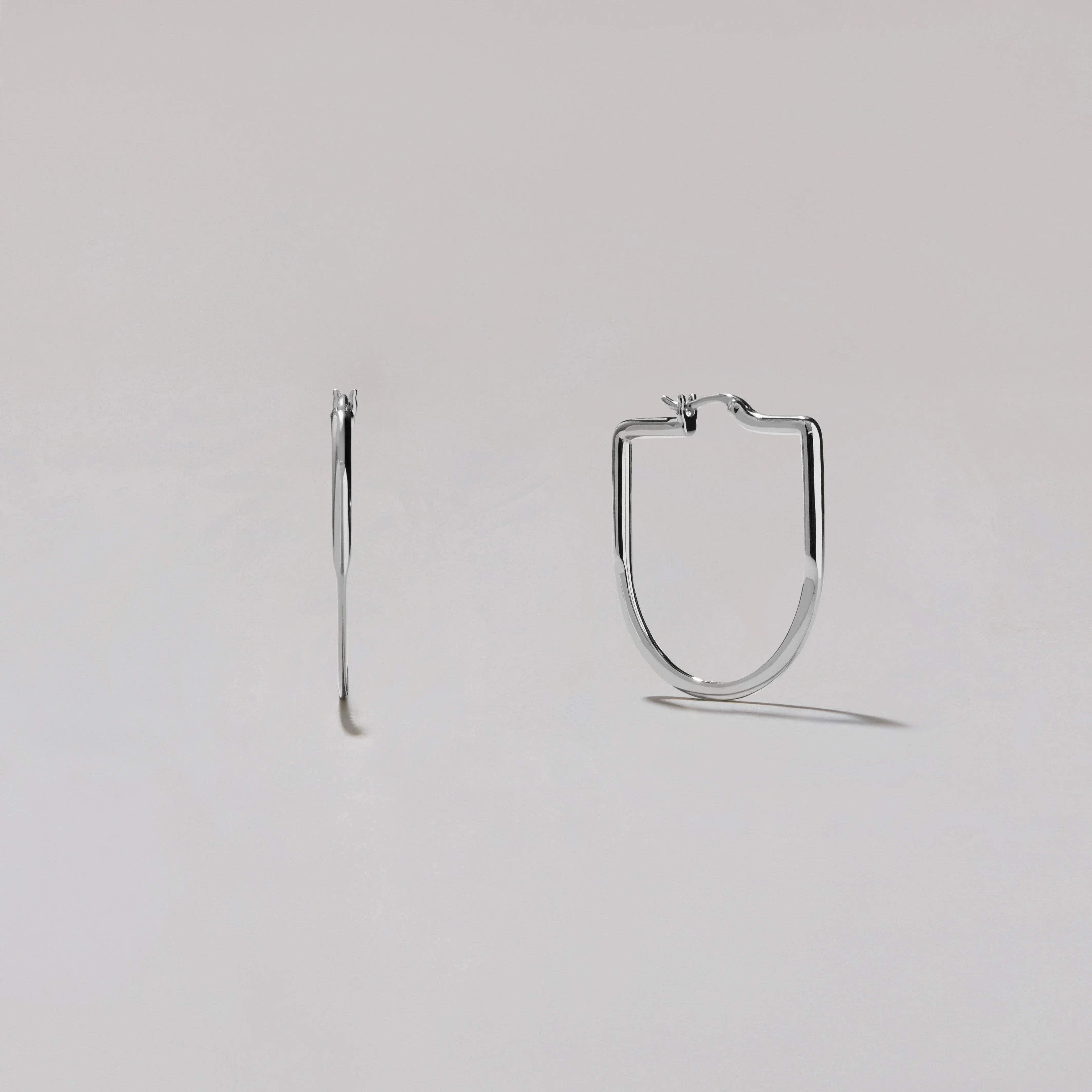 Silver hoop earrings on a light gray background