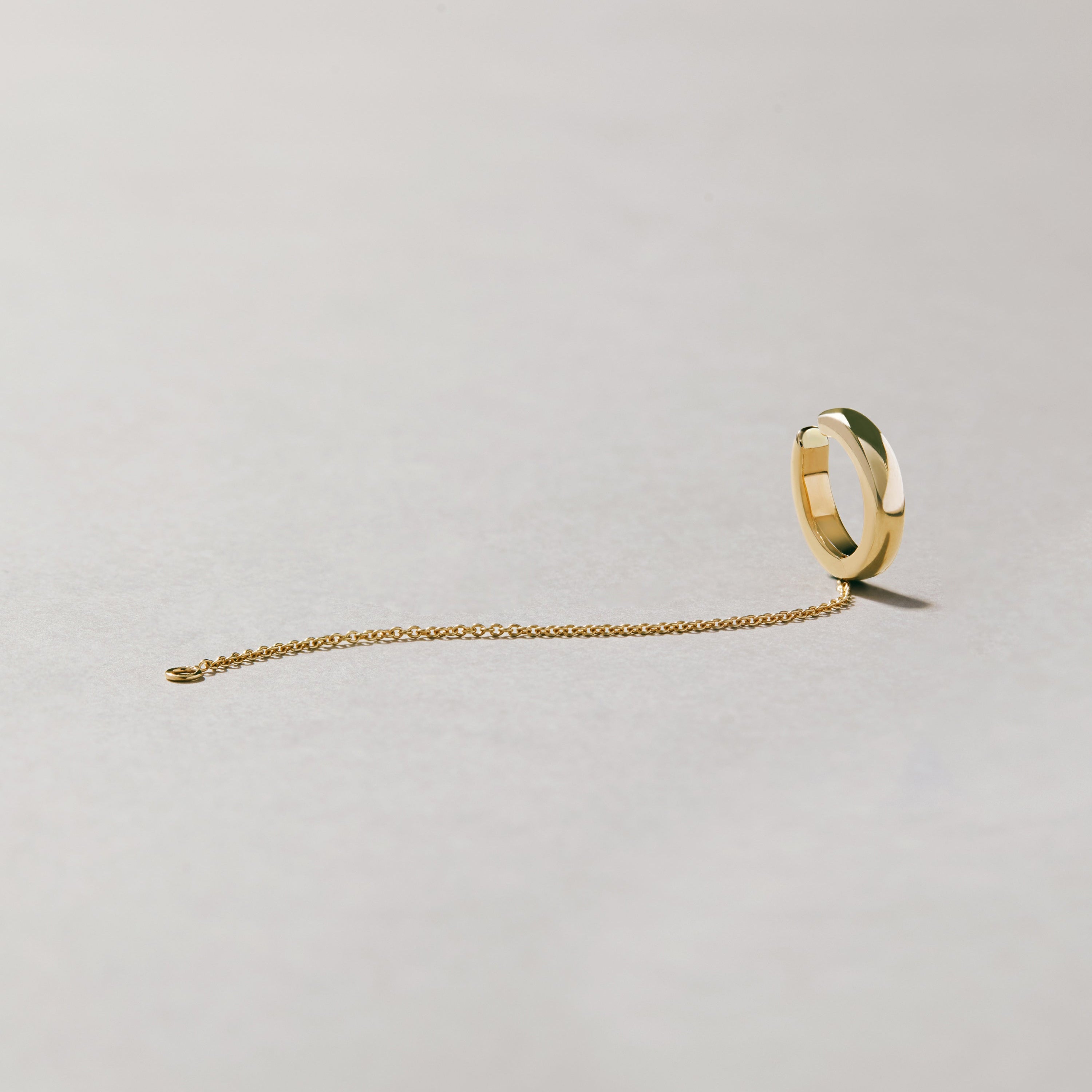 Polished gold-tone ear cuff with minimalist chain design