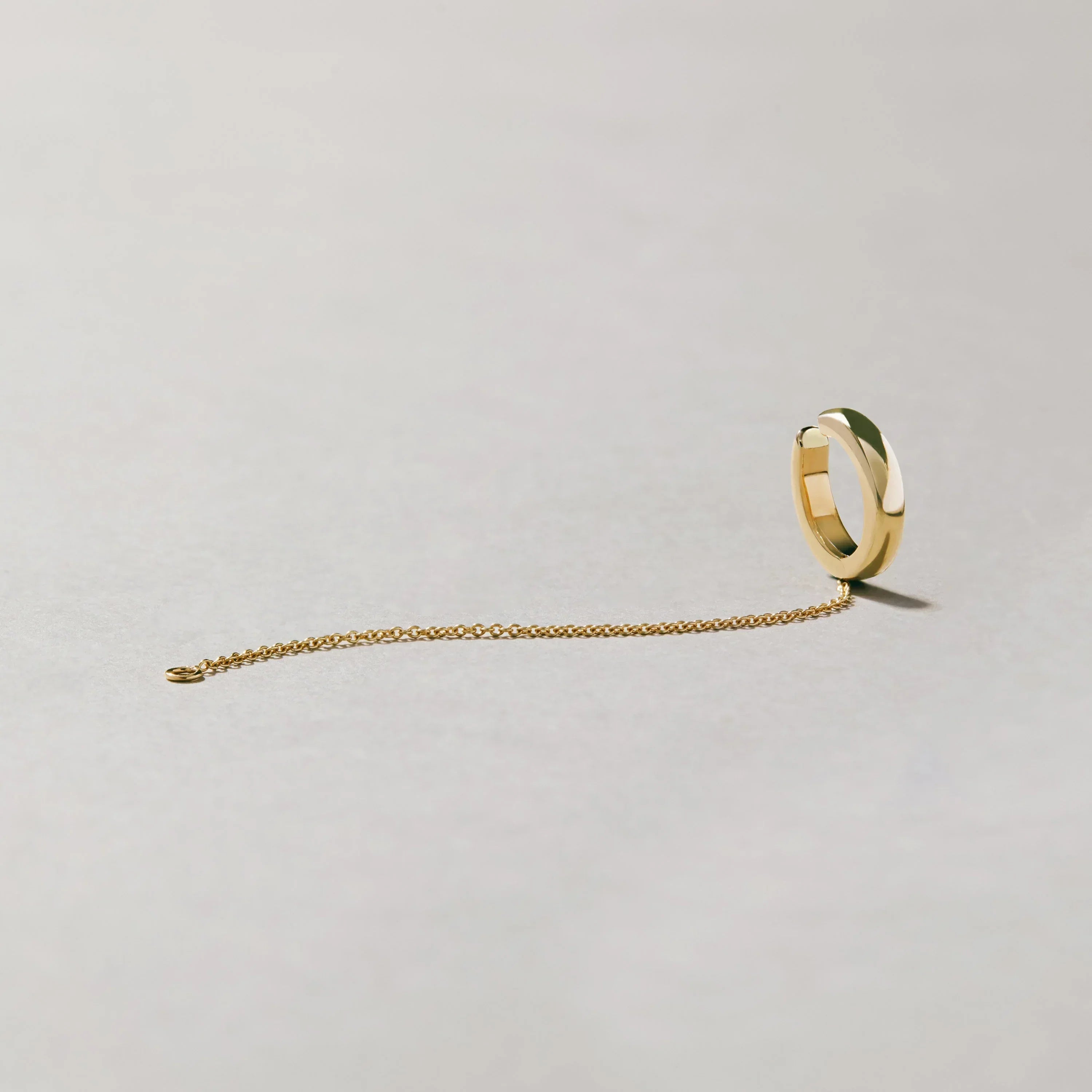 Polished gold-tone ear cuff with minimalist chain design
