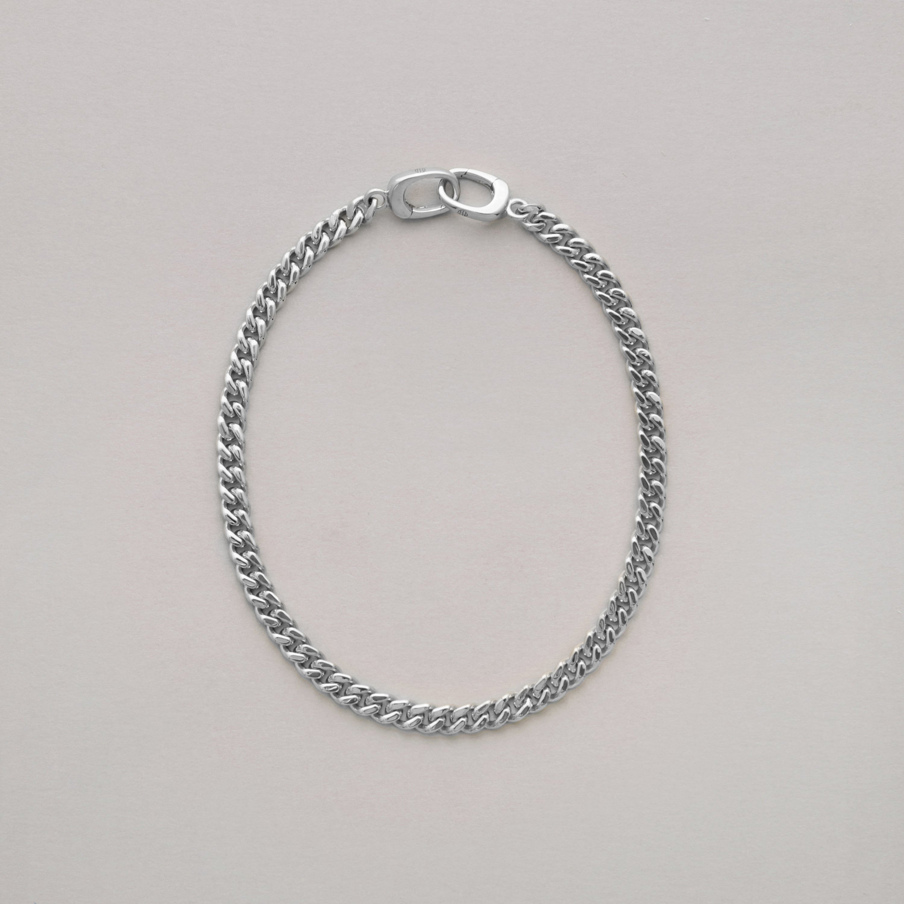 Silver chain bracelet on a light gray background