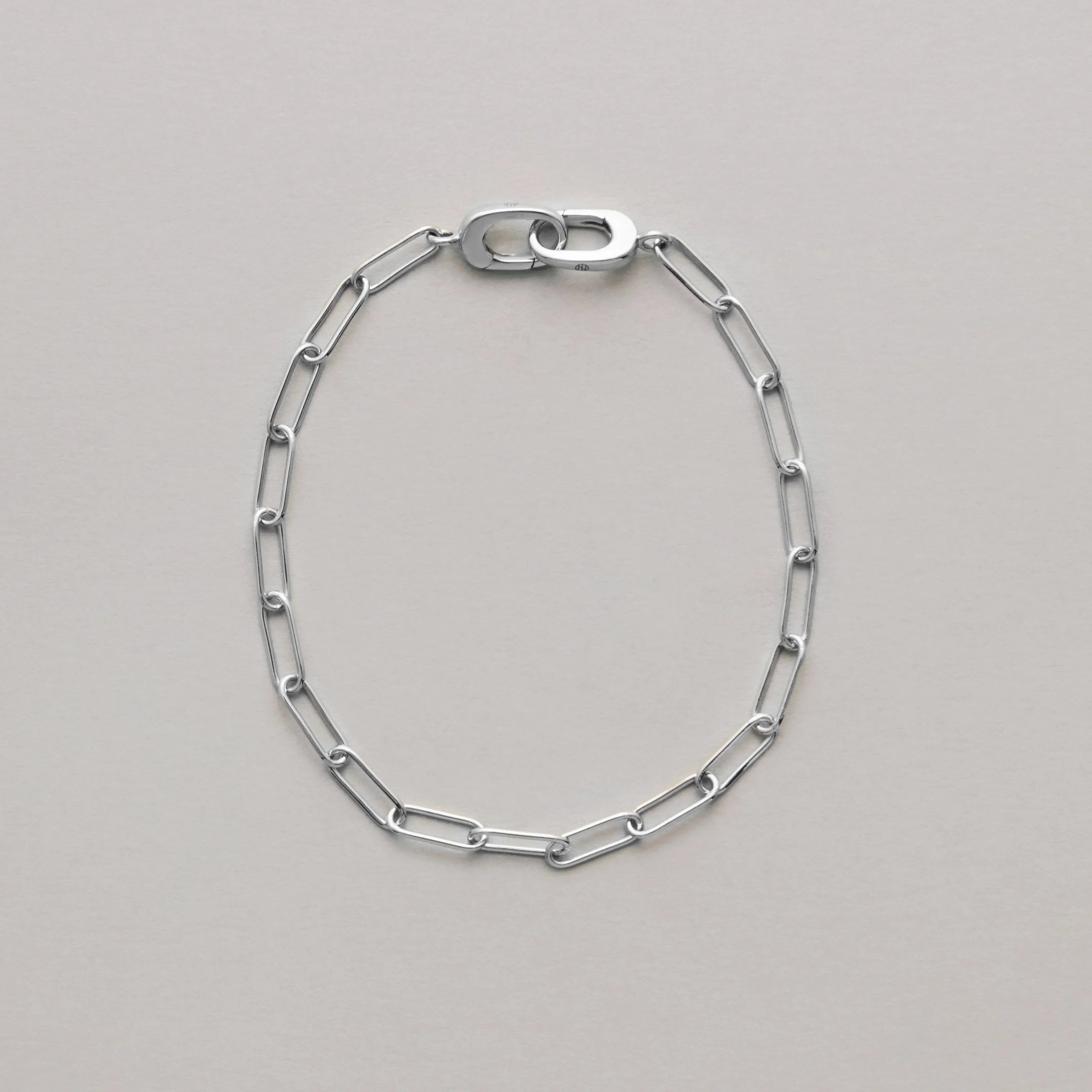 Silver paperclip chain bracelet on a light gray background