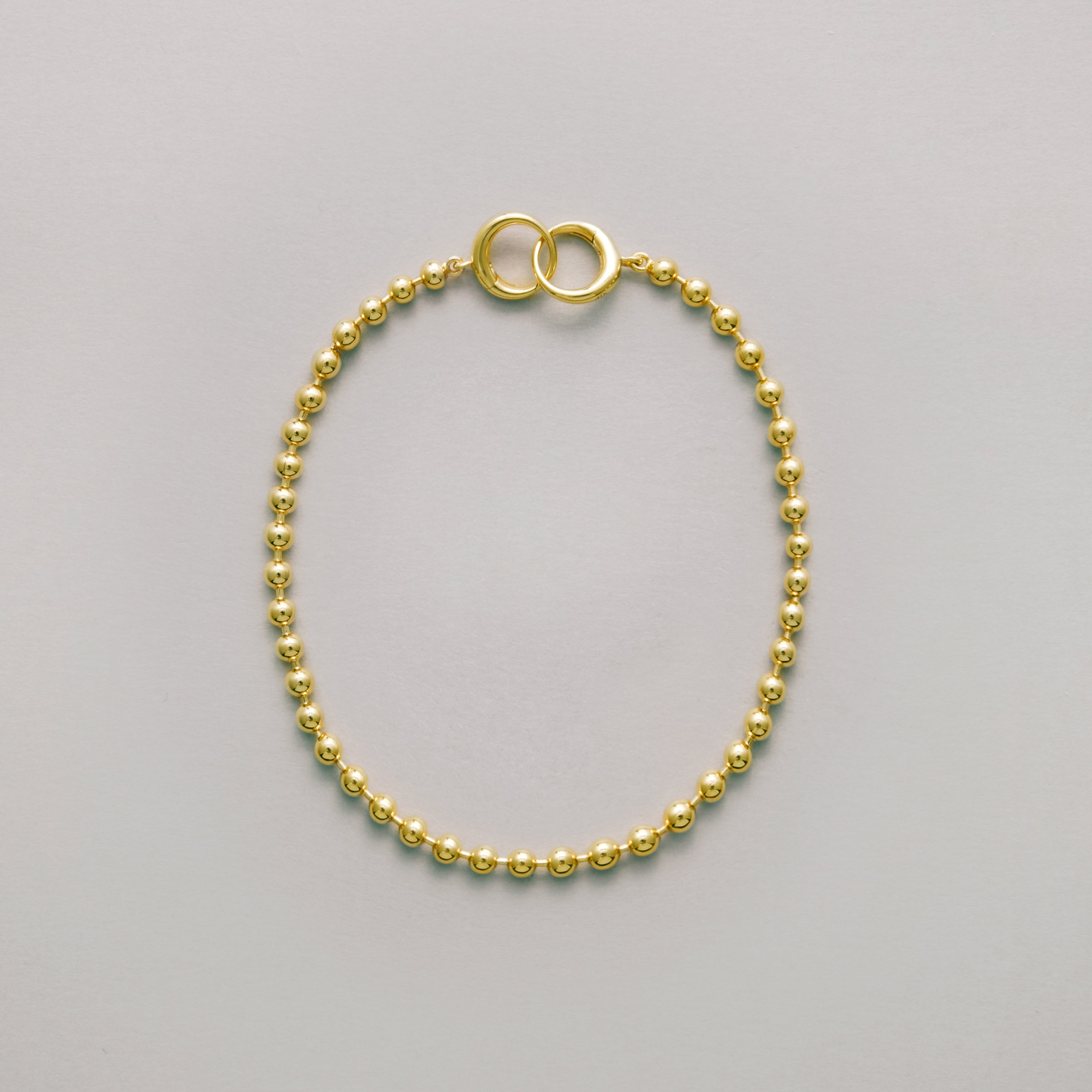 Classic gold ball chain bracelet with interlocking ring clasp laid flat