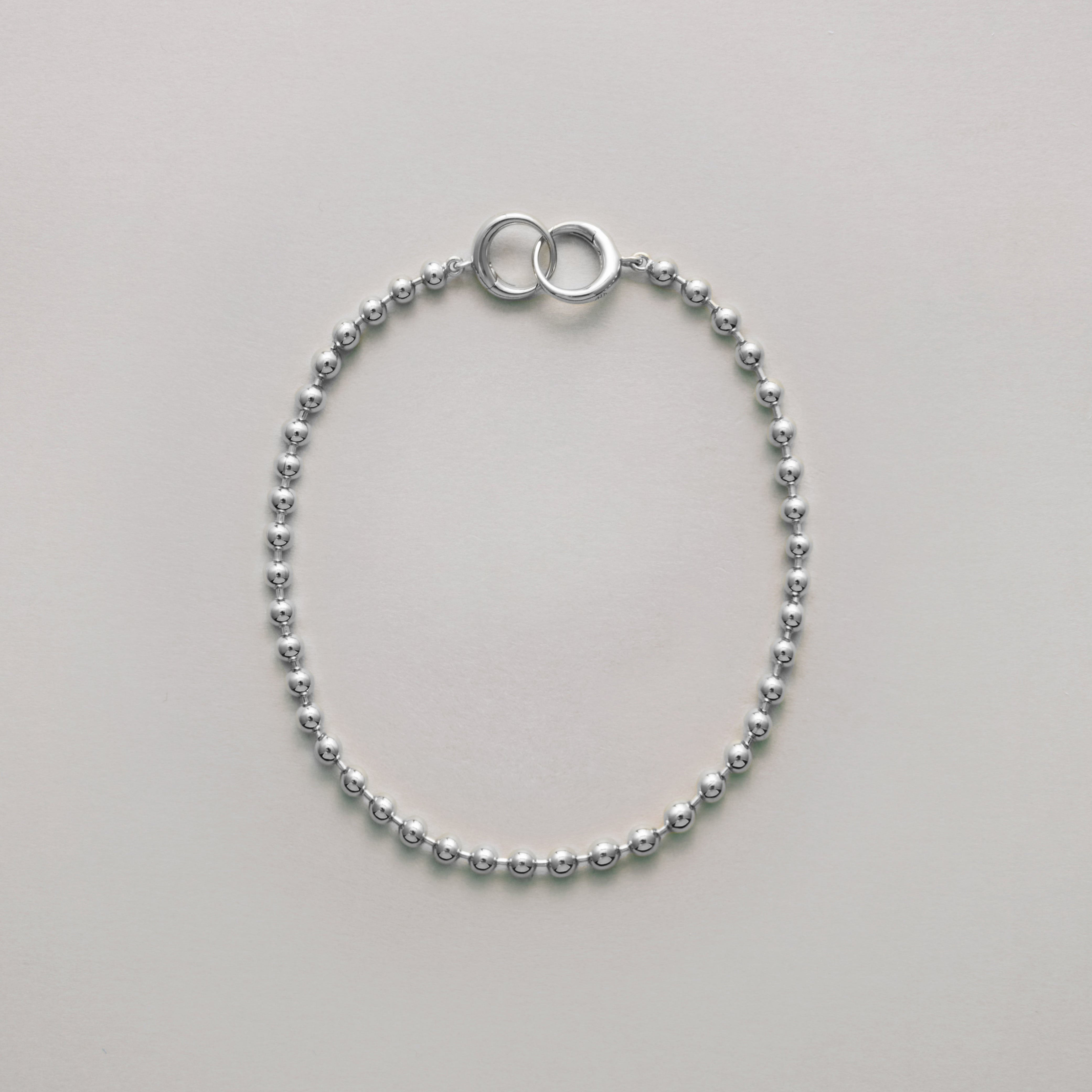 Classic silver ball chain bracelet with interlocking ring clasp laid flat