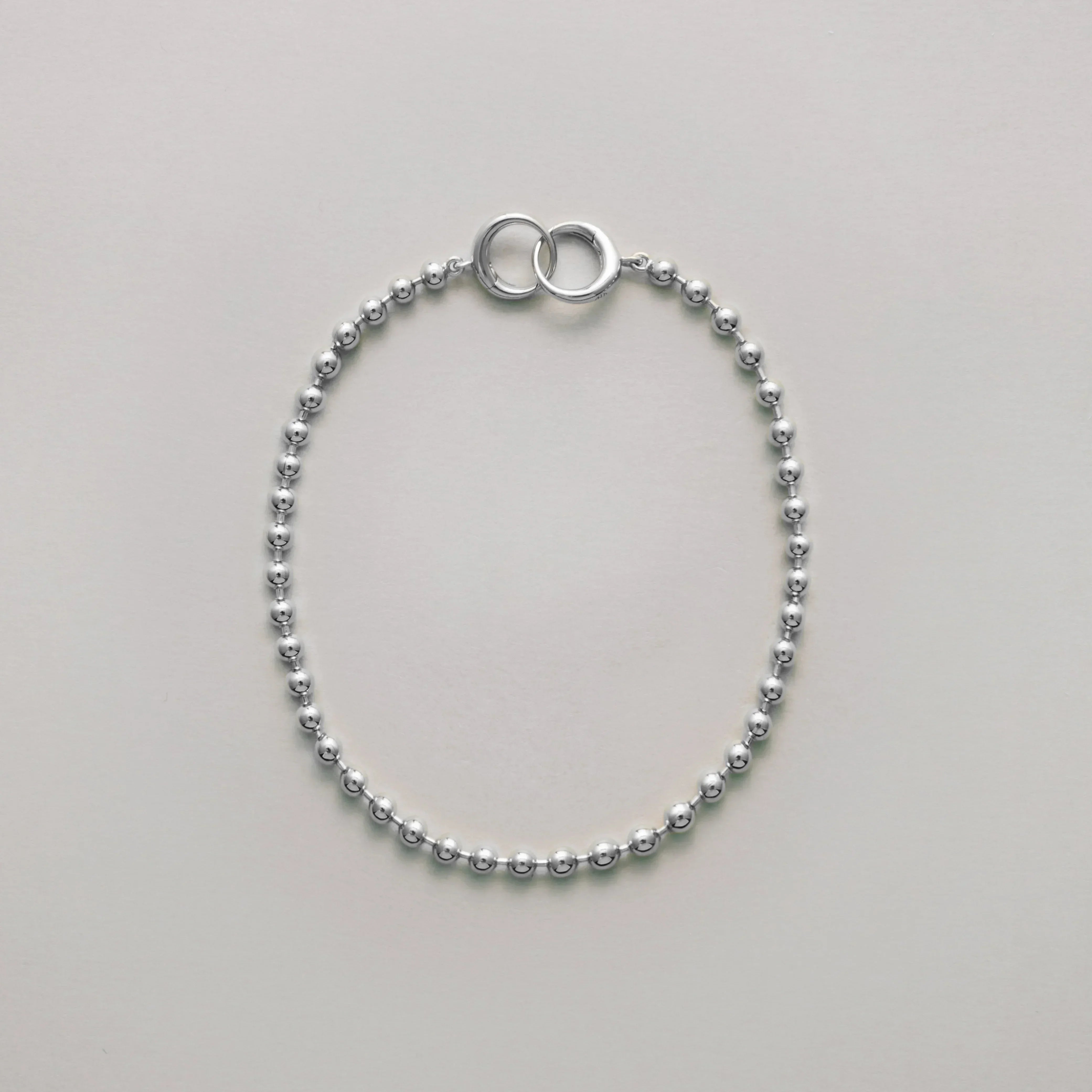 Classic silver ball chain bracelet with interlocking ring clasp laid flat