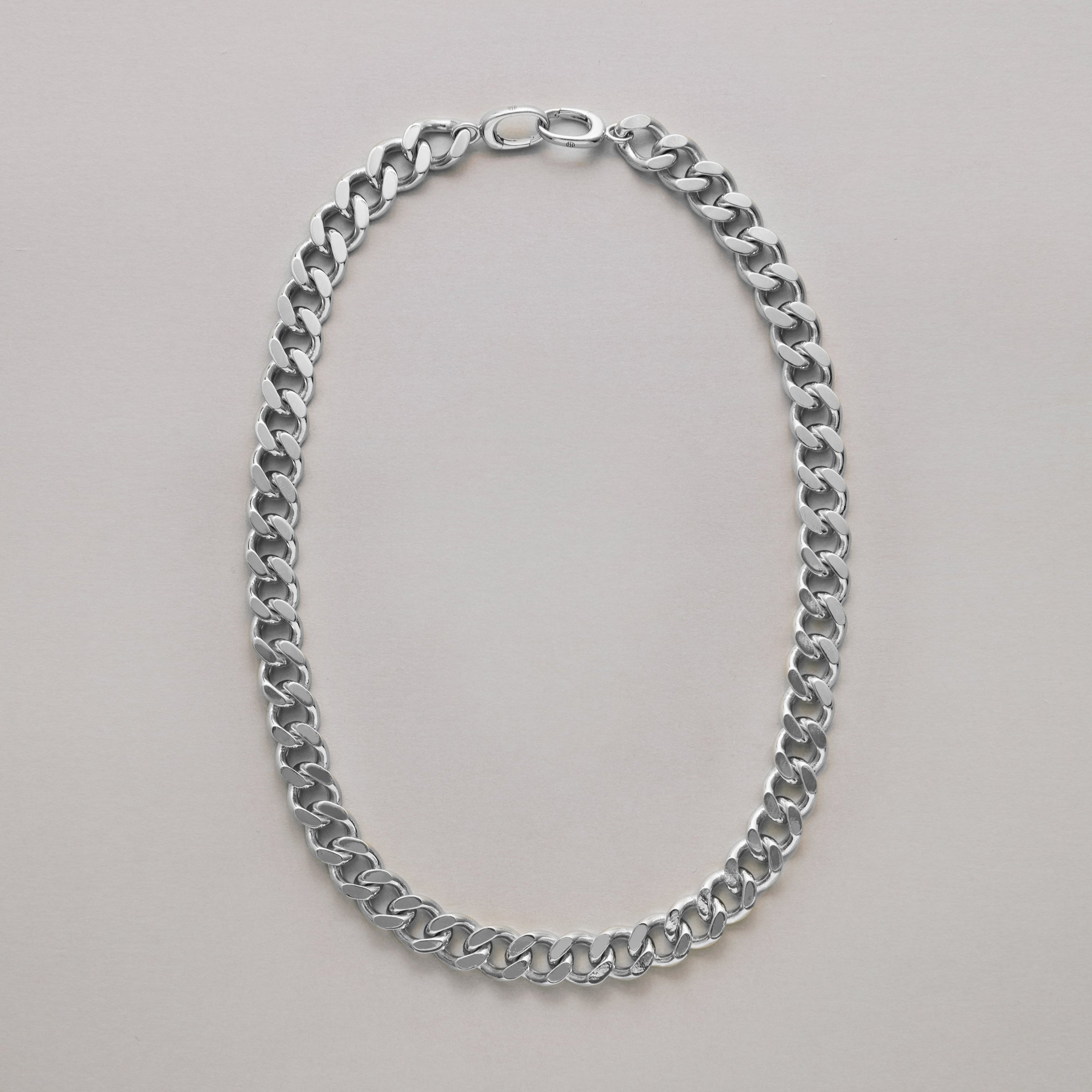Silver cuban chain necklace on a light gray background