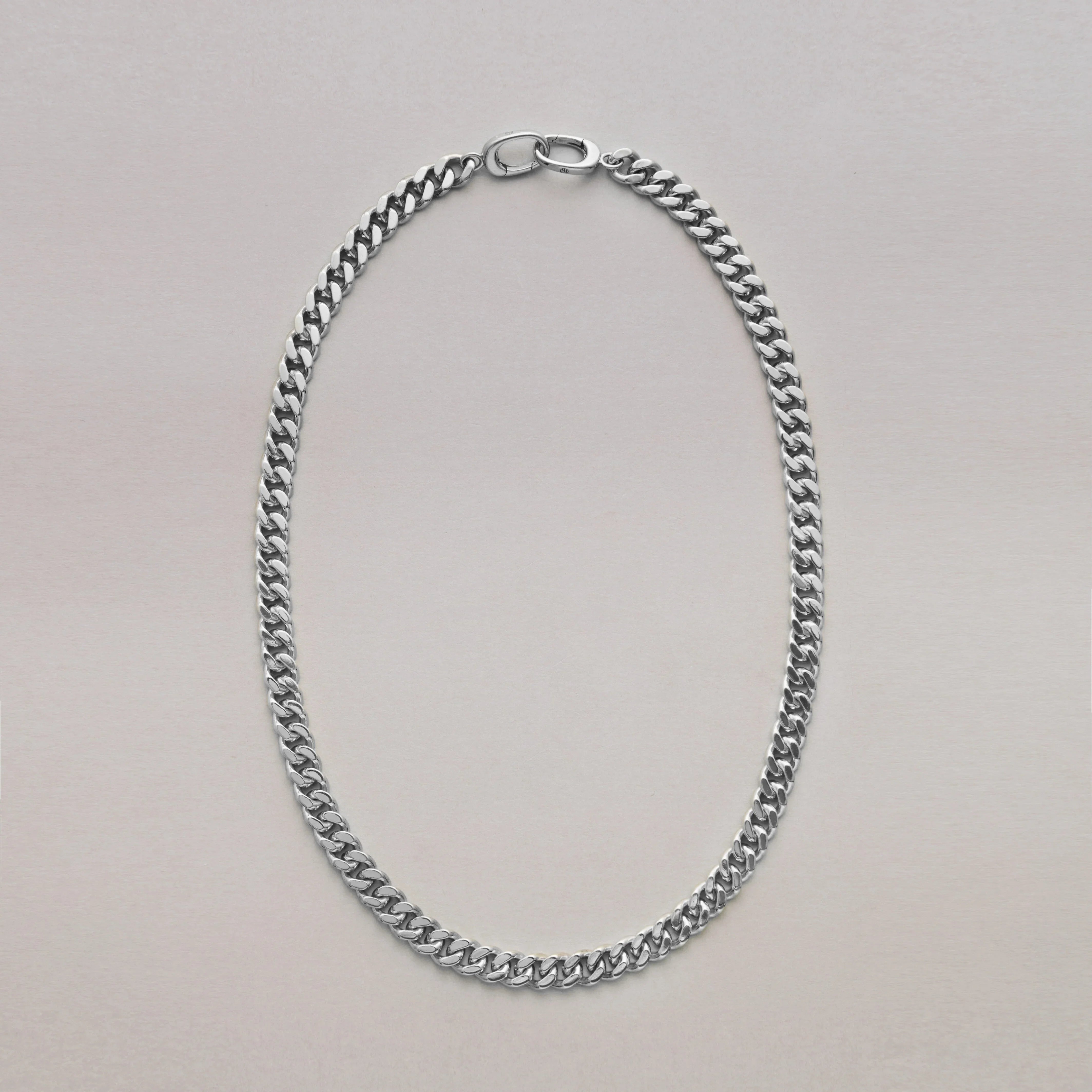 Silver Cuban chain necklace on a light gray background