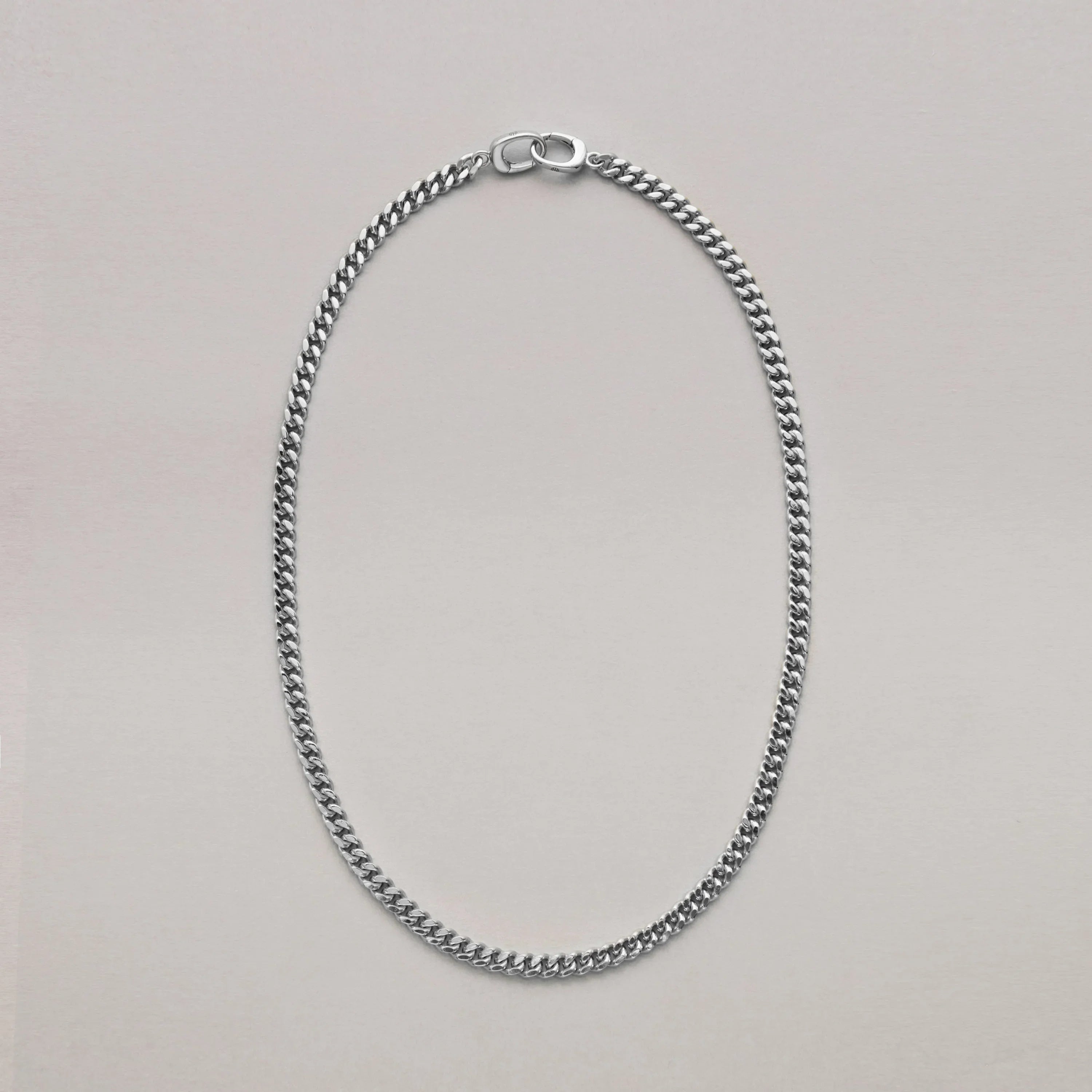 Sleek silver Cuban chain necklace on a light gray background