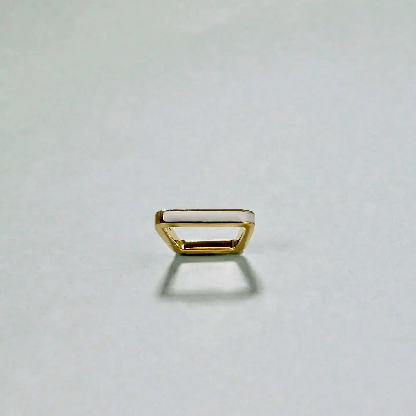 Gold ring on a light gray background