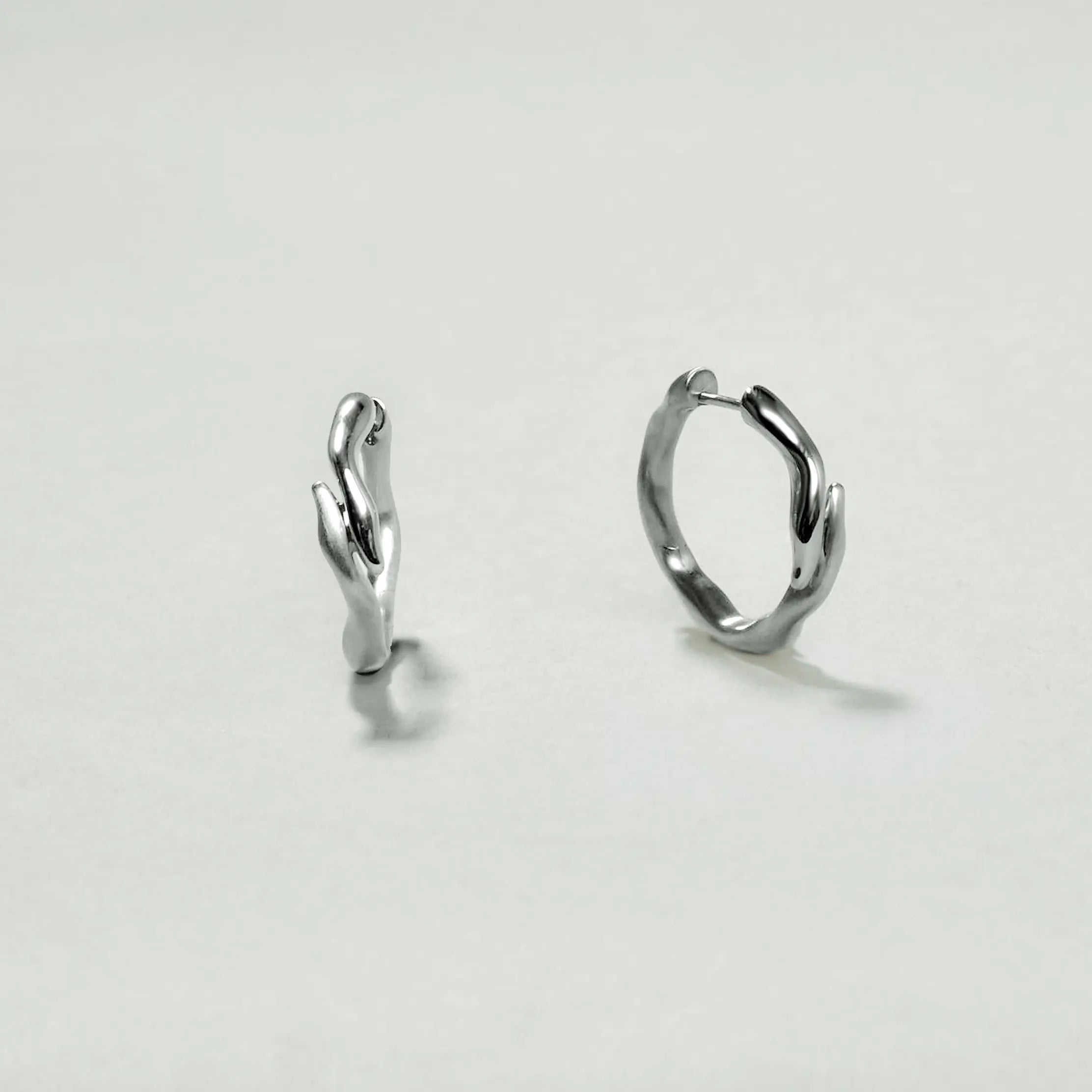 Pair of silver hoop earrings on a light gray background
