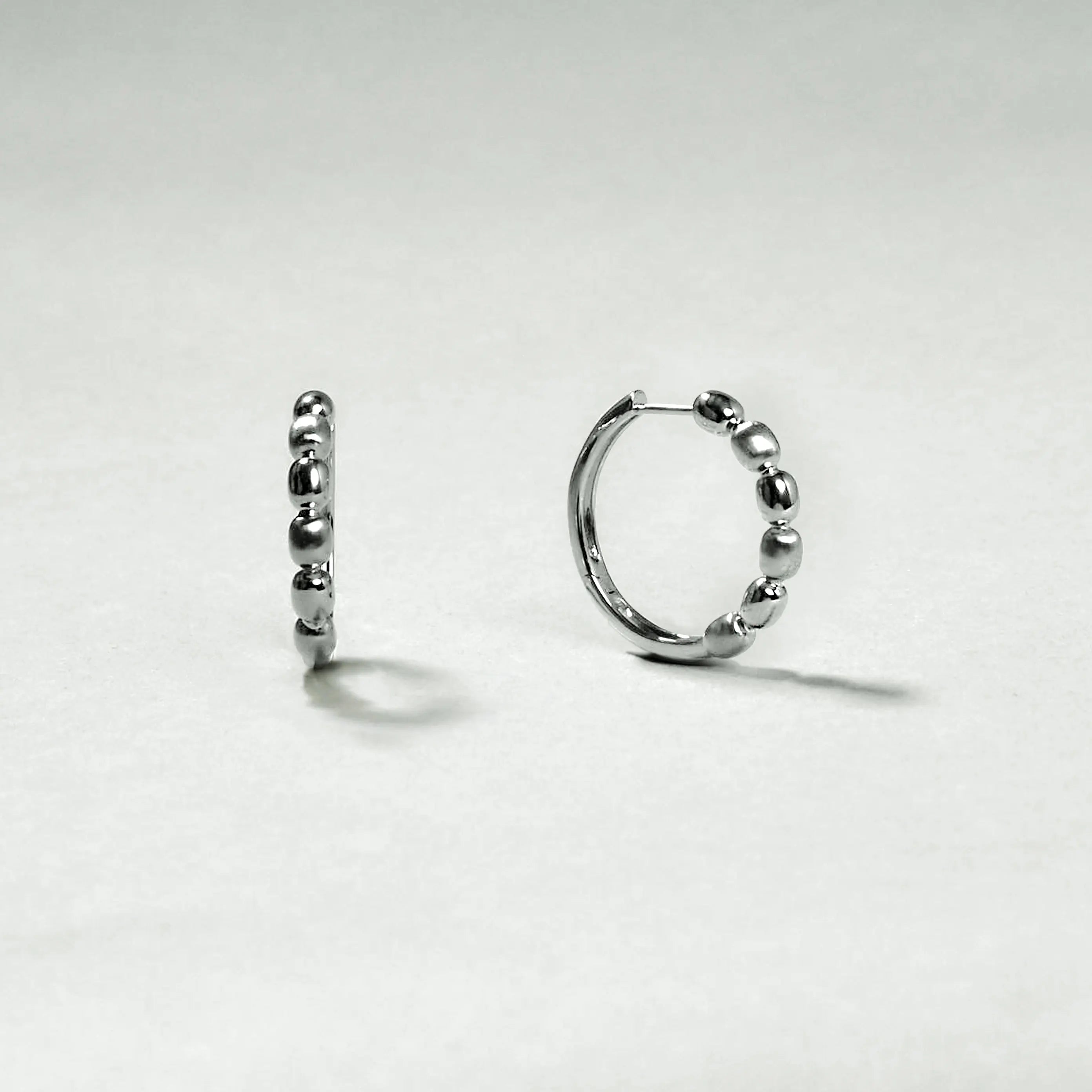 Silver hoop earrings on a light gray background