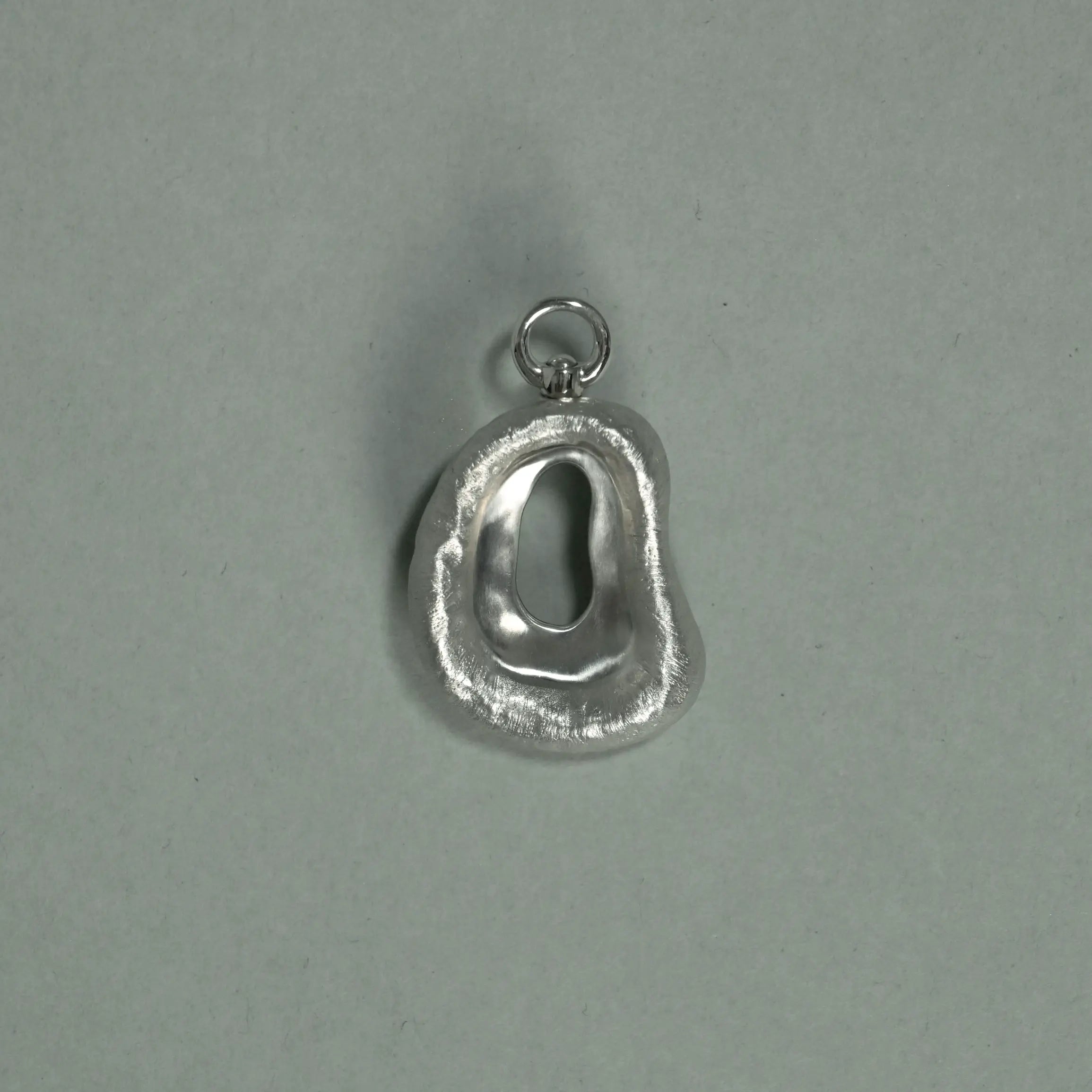 Silver pendant on a gray background