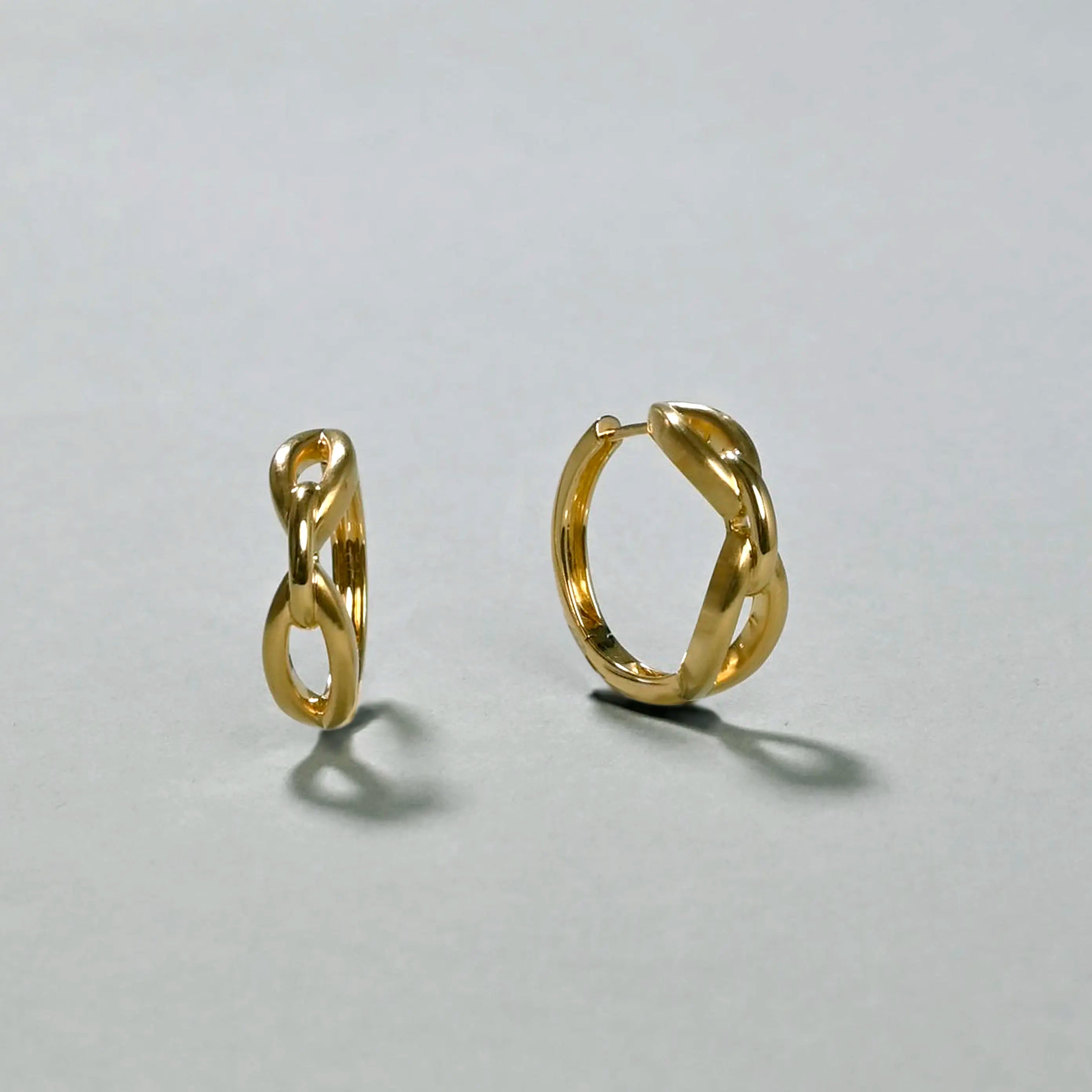 Pair of gold hoop earrings on a light gray background