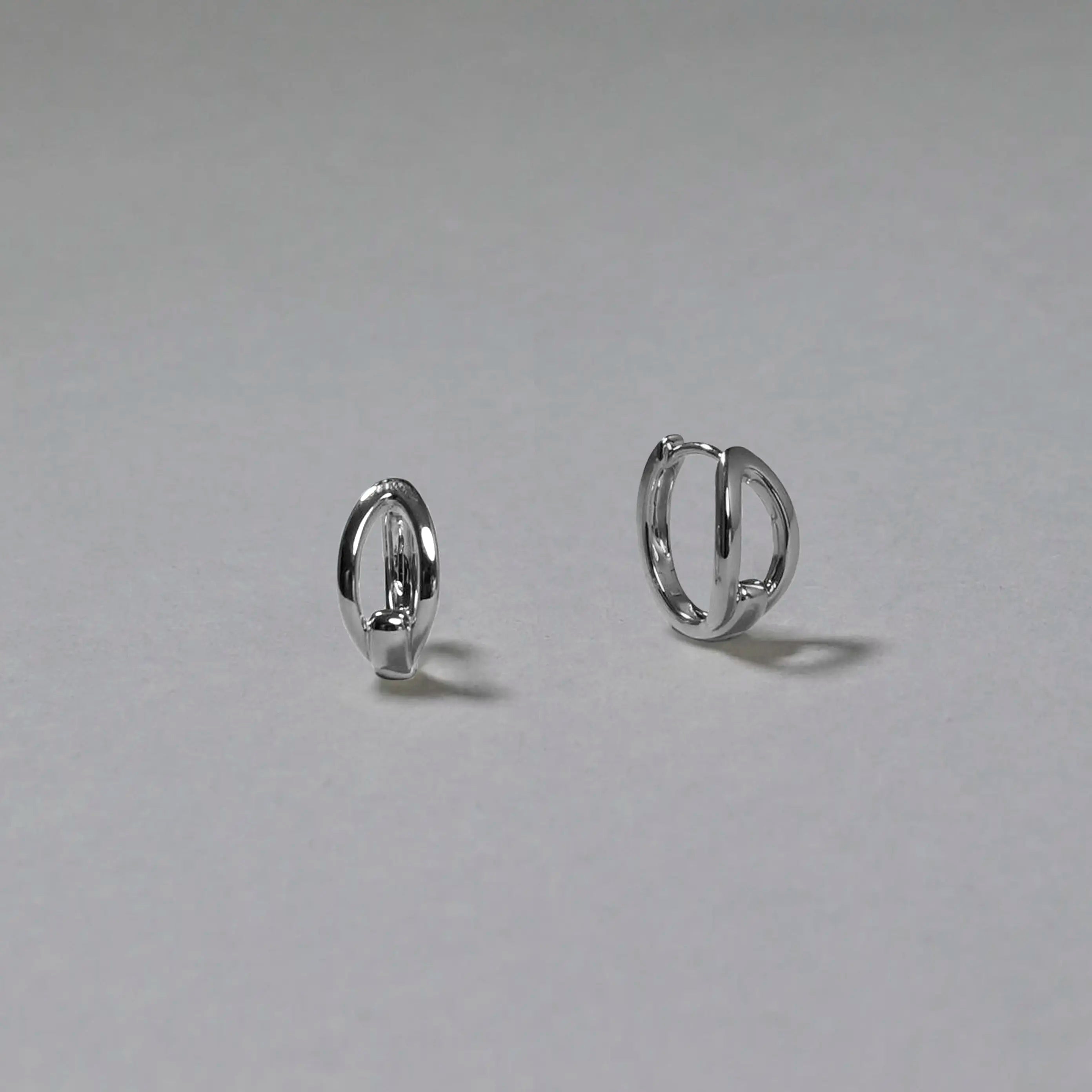 Pair of silver hoop earrings on a gray background