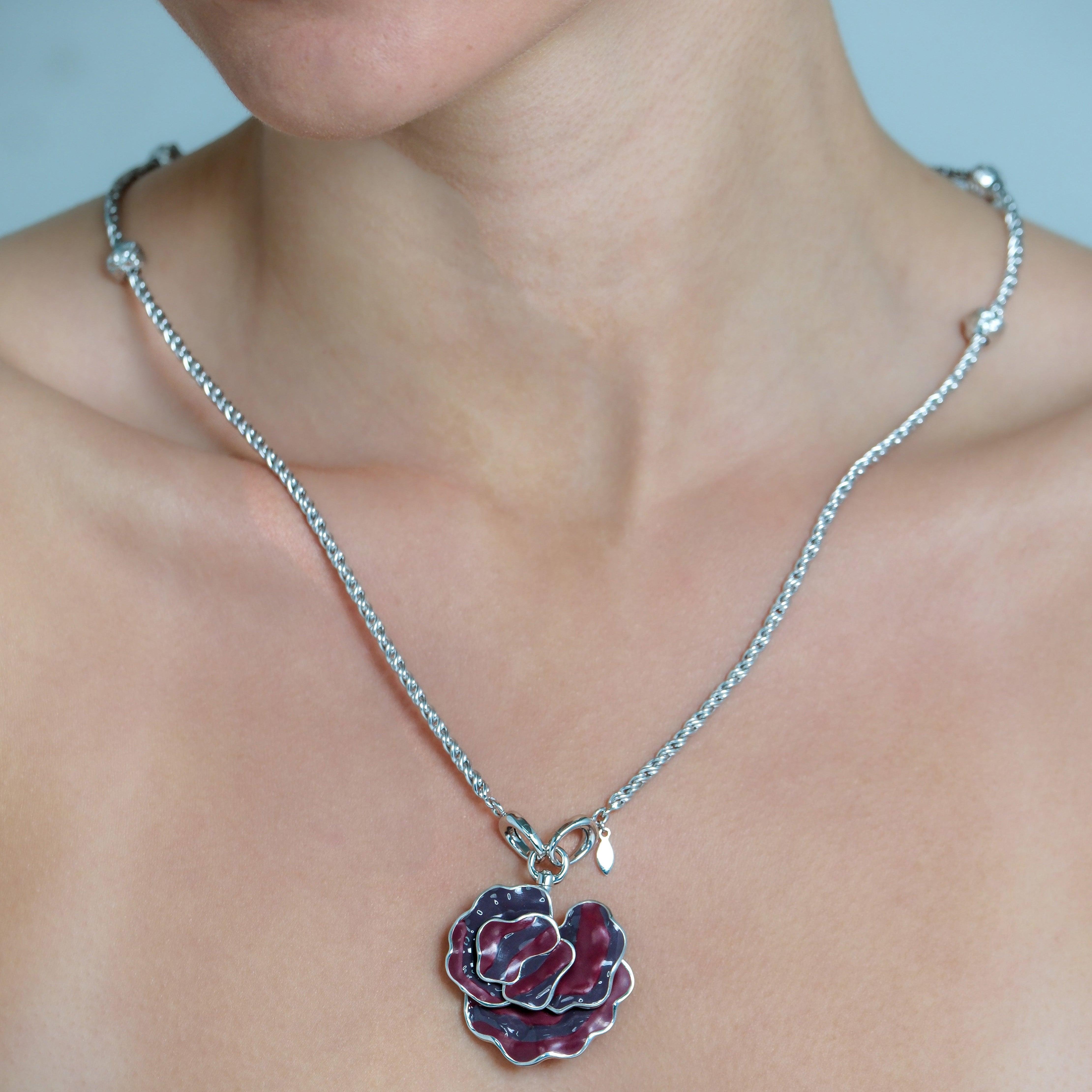 Necklace with a floral pendant worn by a person