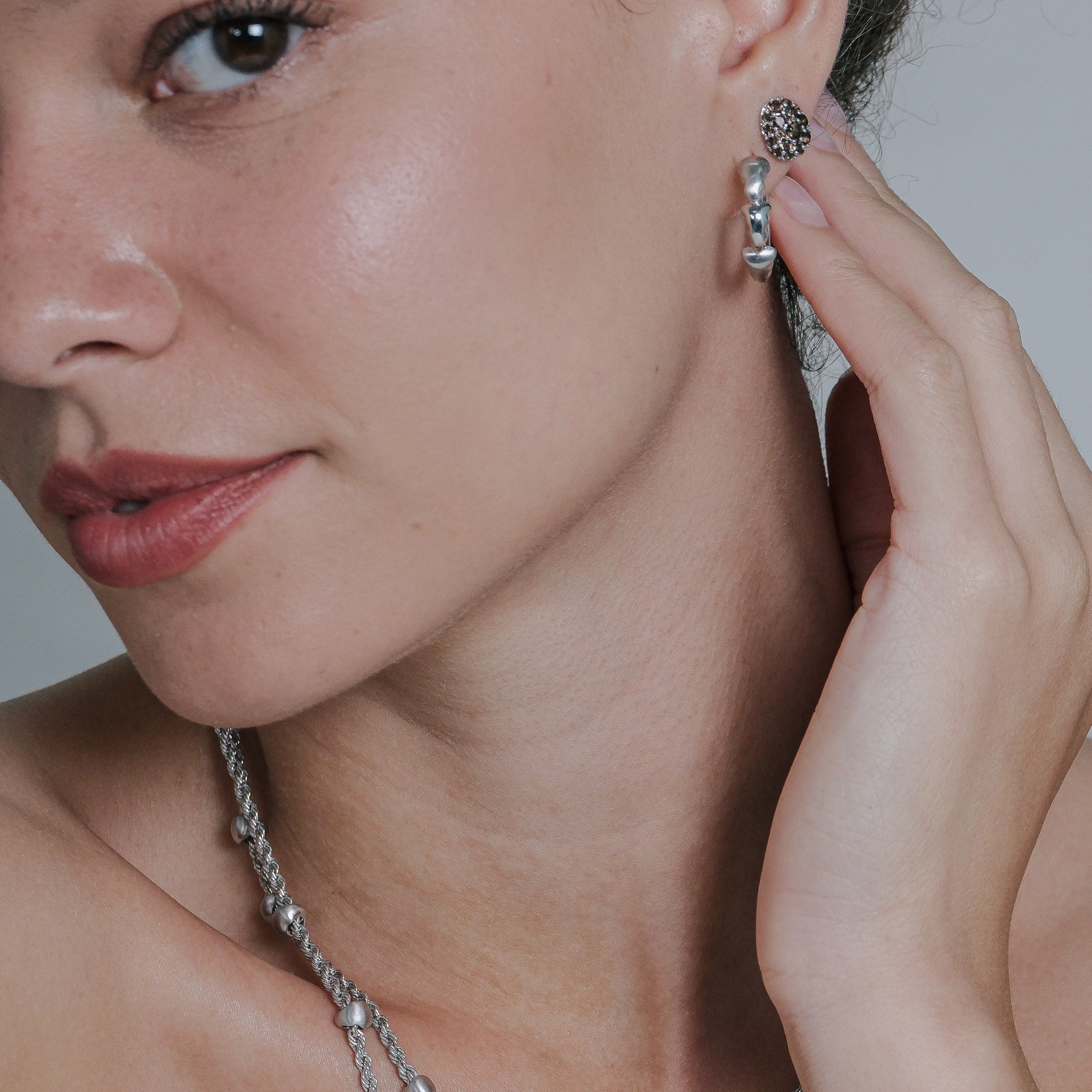 Woman wearing earrings on a neutral background