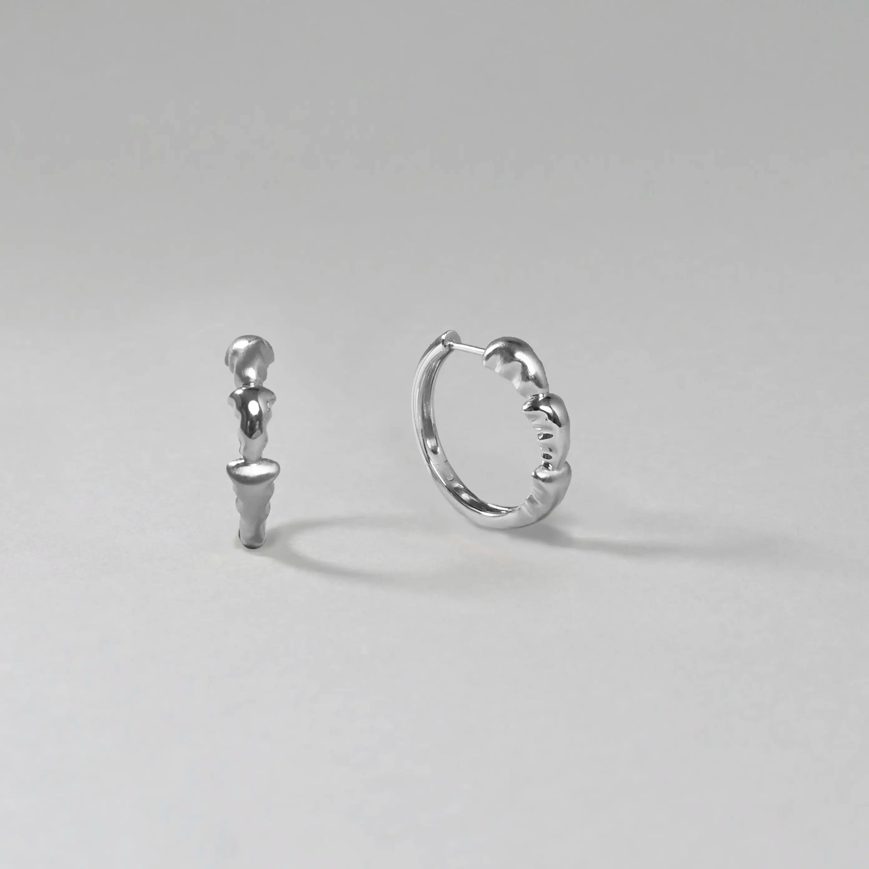 Pair of silver hoop earrings on a light gray background