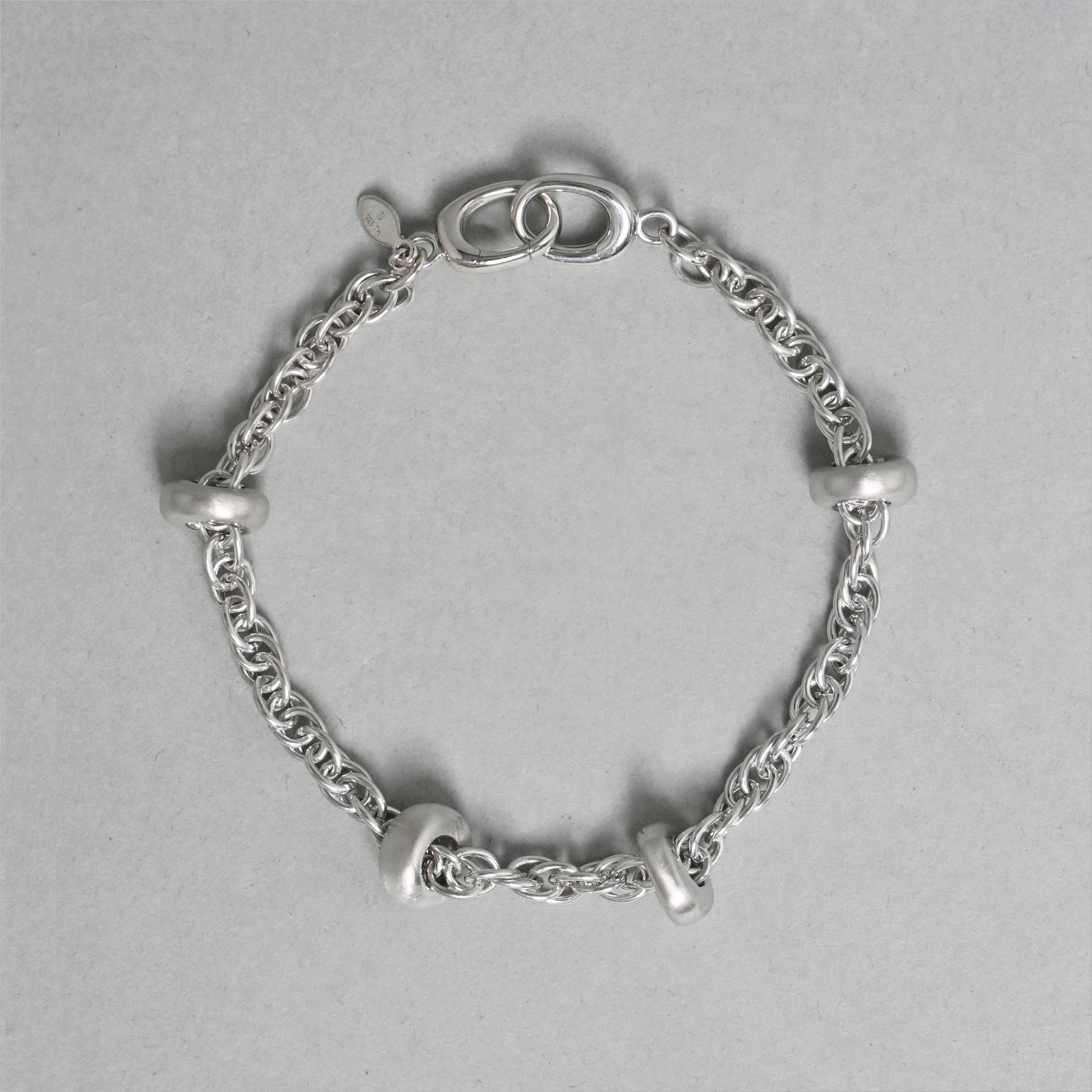 Silver chain bracelet on a gray background