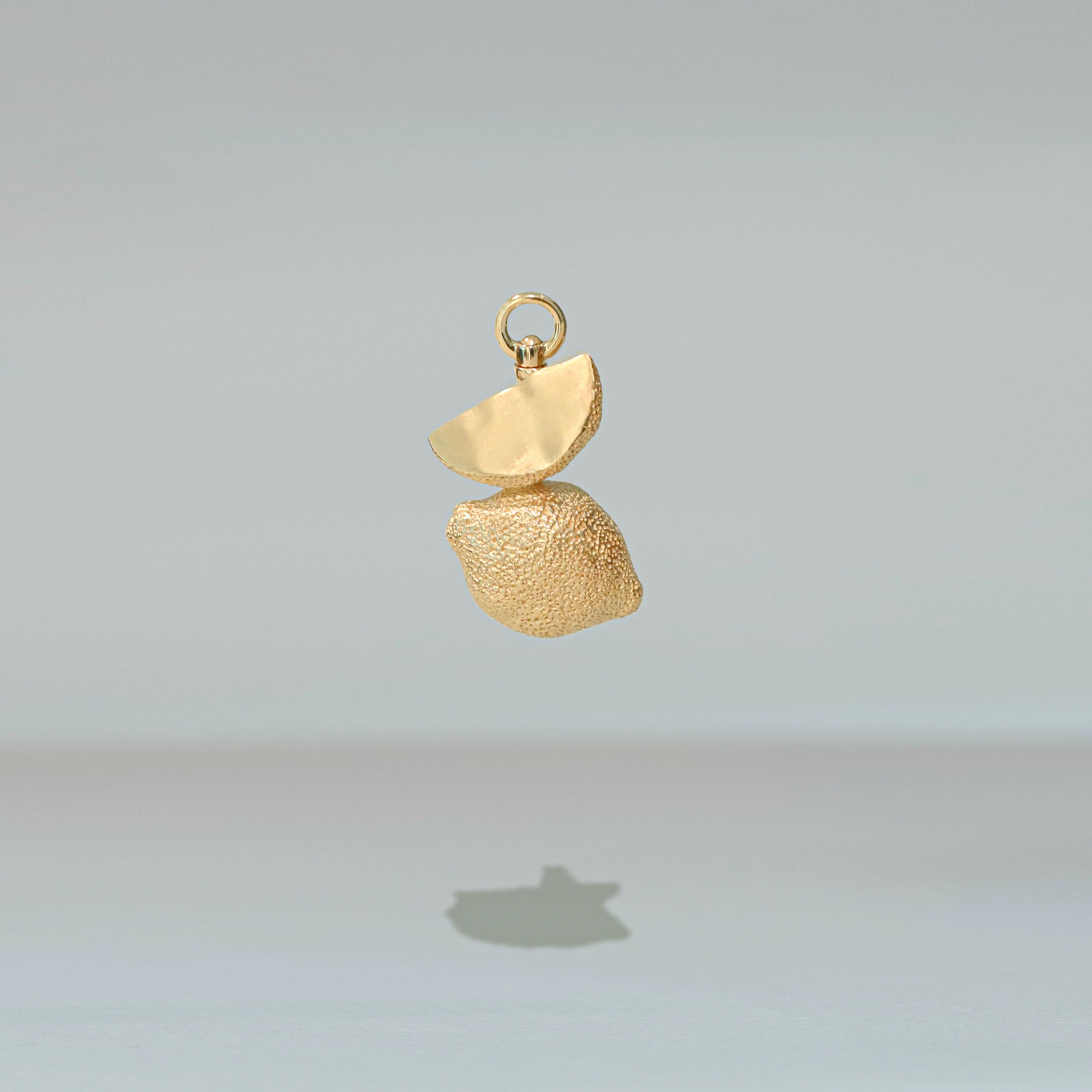 Gold pendant on a light gray background