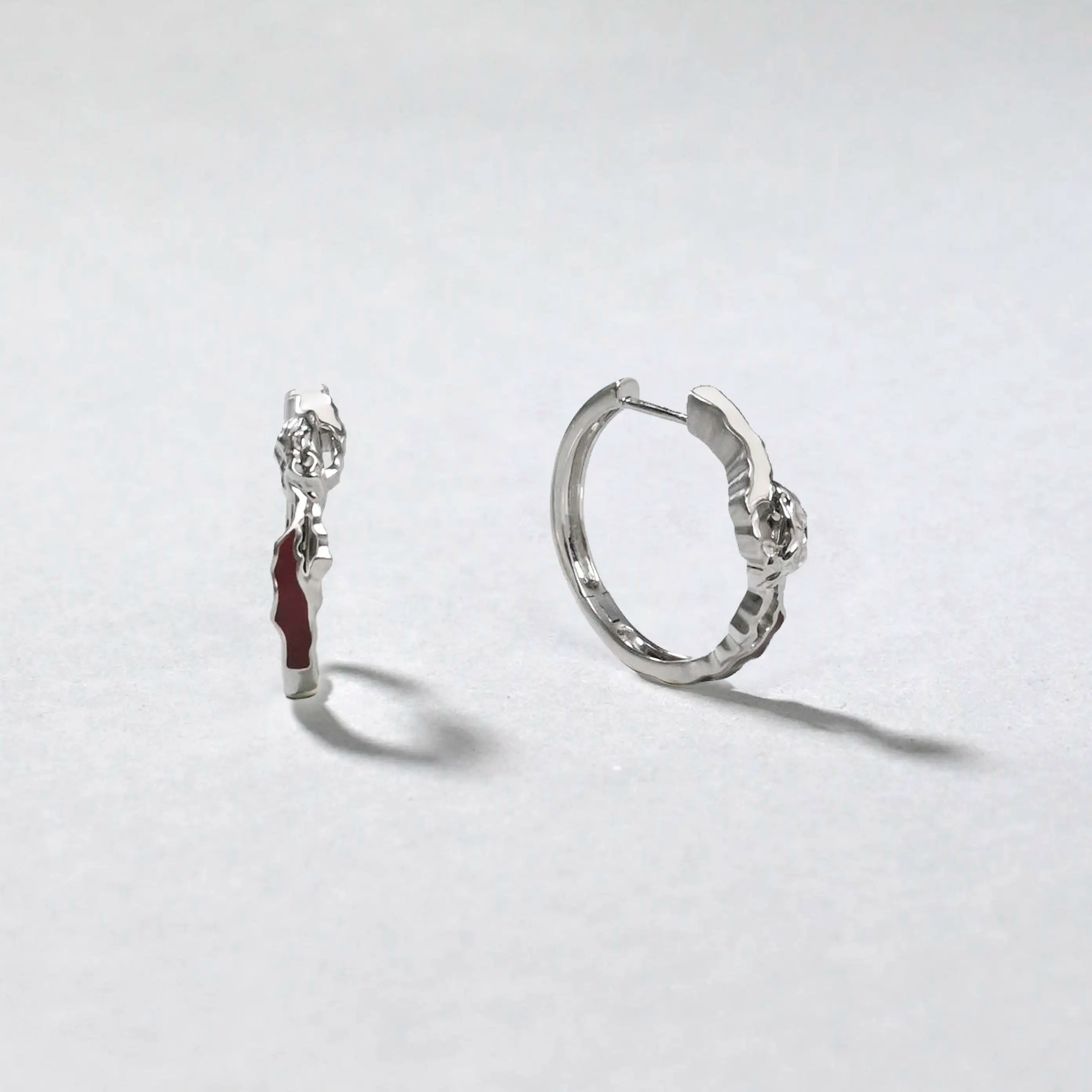 Pair of silver hoop earrings on a light gray background